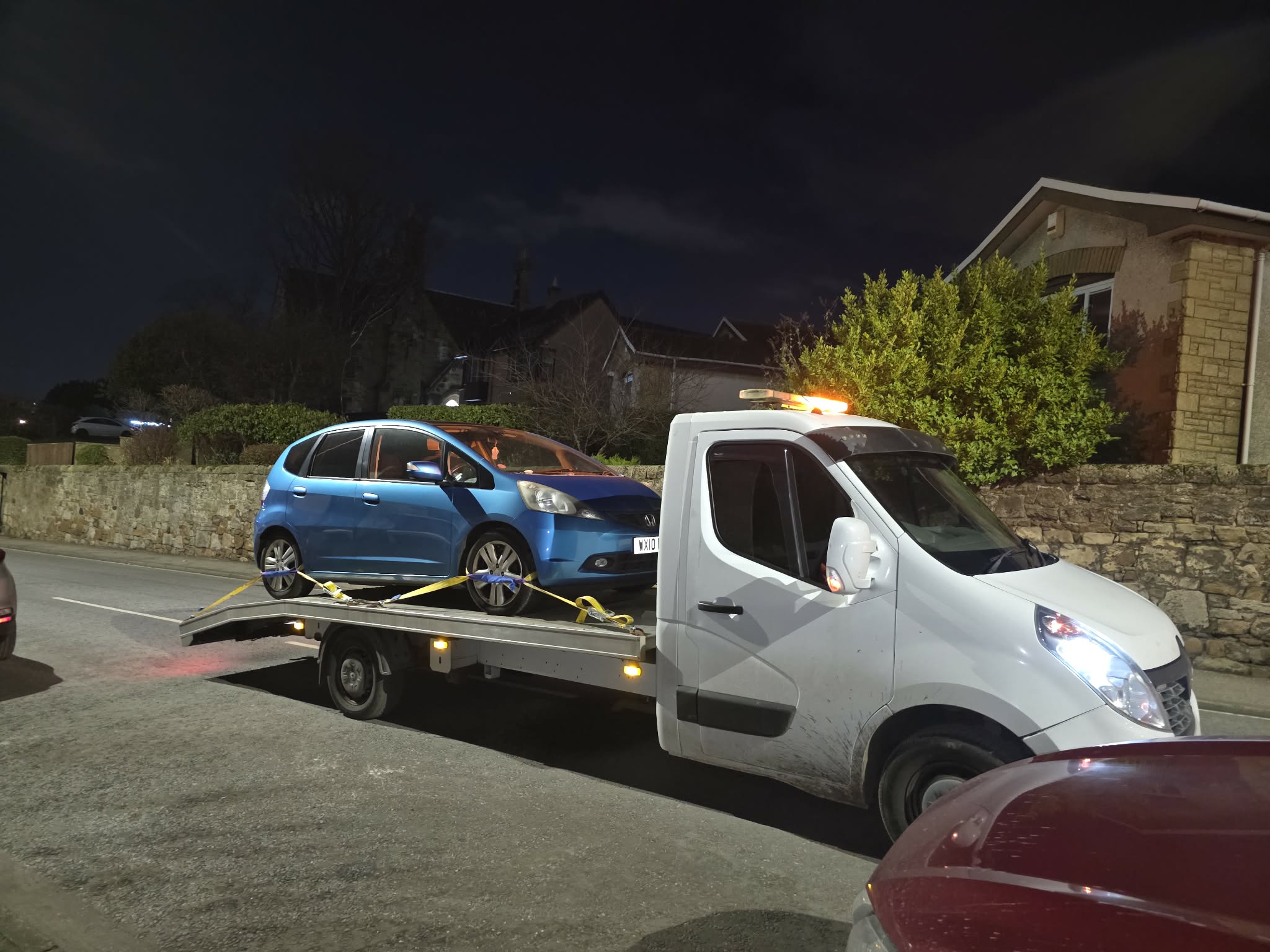 Late night vehicle recovery of a blue hatchback in a residential street