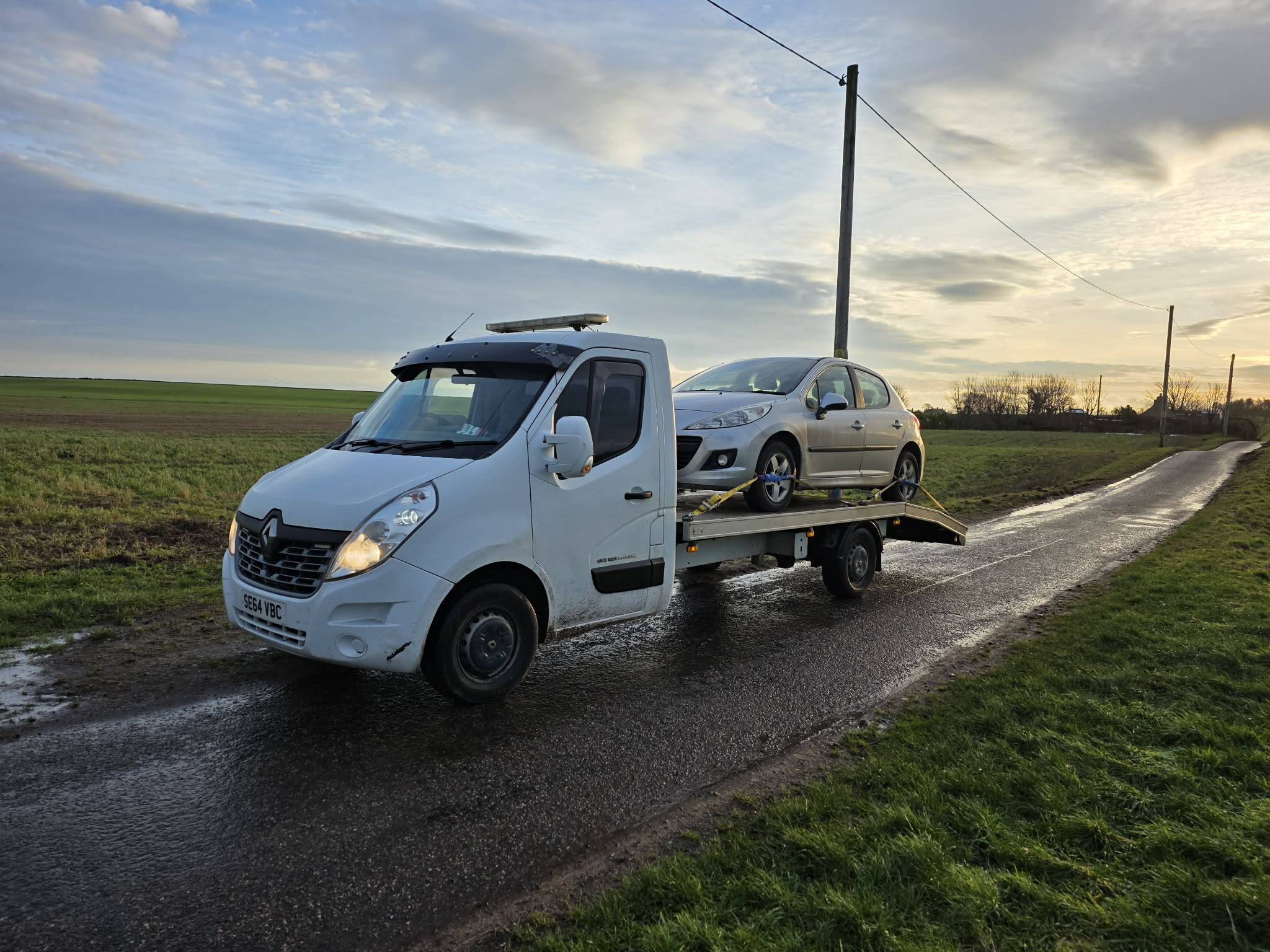 GTT Recovery transporting a silver car along a rural Fife road at sunset